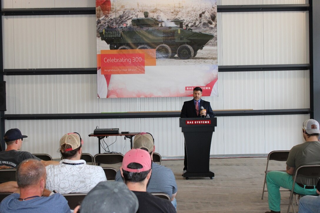 Chris Melkonian speaks before an audience at an Amphibious Combat Vehicle manufacturing facility