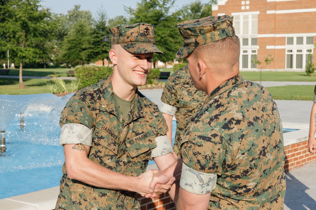U.S. Marine Corps Master Gunnery Sgt. Robert Withers (right) shakes hands with 2nd Lt. William Hardwick (left), 1st Marine Corps District, during the commissioning ceremony at Marine Corps Base Quantico, Virginia, August 4, 2025. The Enlisted to Judge Advocate program offers selected Marines in the ranks of sergeant to gunnery sergeant a funded opportunity to earn a law degree and serve as a judge advocate. Selectees receive full active-duty pay and benefits while attending Officer Candidates School, law school, and The Basic School. (U.S. Marine Corps photo by Cpl. Memphis Pitts)