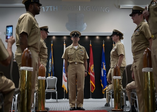 U.S. Navy Cryptologic Technician Collection Chief Petty Officer Neal Williams stands in the center of the sideboys as he prepares to walk and salute at Goodfellow Air Force Base, Texas.