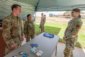 2nd Lt. Bernardo Rozewicz, chaplain and Senior Master Sgt. Amber Kamai, religious affairs advisor of the 624th Regional Support Group, shares resources with Staff Sgt. Stephanie Czarzasty, commander’s support staff specialist, during a Mental Health Resource Fair at Joint Base Pearl Harbor-Hickam, Hawaii, on Sept. 6, 2025.