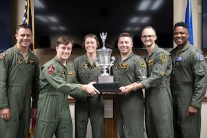 Lt. Col. James Bresnahan, 11th Bomb Squadron commander, and Lt. Col. Millard Matthews, III, 93rd Bomb Squadron commander, pose with an FTU aircrew