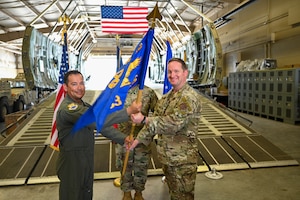 Col. Michael Medrano, 433rd Operations Group interim commander, presents the 433rd Contingency Response Squadron guidon to Major Alexander Williams, 433rd CRS commander, during a redesignation ceremony at Joint Base San Antonio-Lackland, Texas, Sept. 6, 2025.