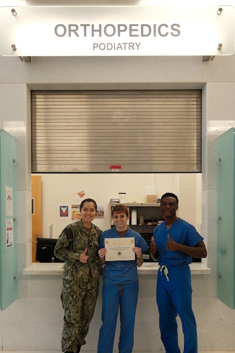 The Orthopedics department of U.S. Naval Hospital Guam is recognized by the Military Health System Joint Outpatient Experience Survey and is awarded for 100% Satisfaction for Fiscal Year 2025 Quarter 2. From left to right: Hospital Corpsman 3rd Class (HM3) Tran Ly, HM3 Sophia Anderson, Hospital Corpsman 2nd Class (HM2) Bernard Claxton, all orthopedics technicians at USNH Guam.