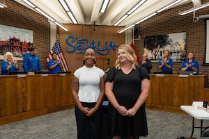U.S. Air Force Senior Airman Jada McMillan, 509th Operational Medical Readiness Squadron medical technician, left, and Darci Curtis, 509th Healthcare Operations Squadron pharmacy technician, are applauded during a city council meeting in Sedalia, Missouri, Sept. 2, 2025.