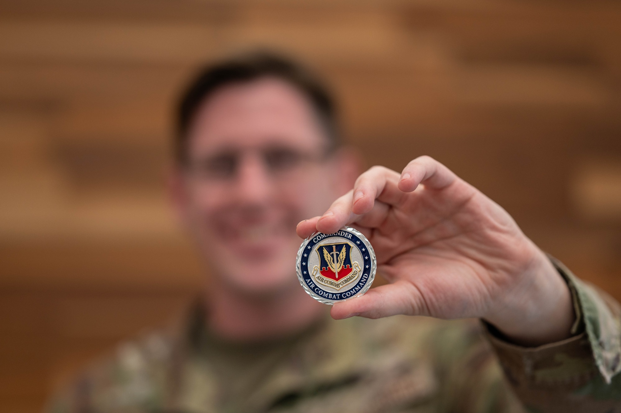 An Airman holds up a coin presented by Gen. Adrian Spain, Air Combat Command commander