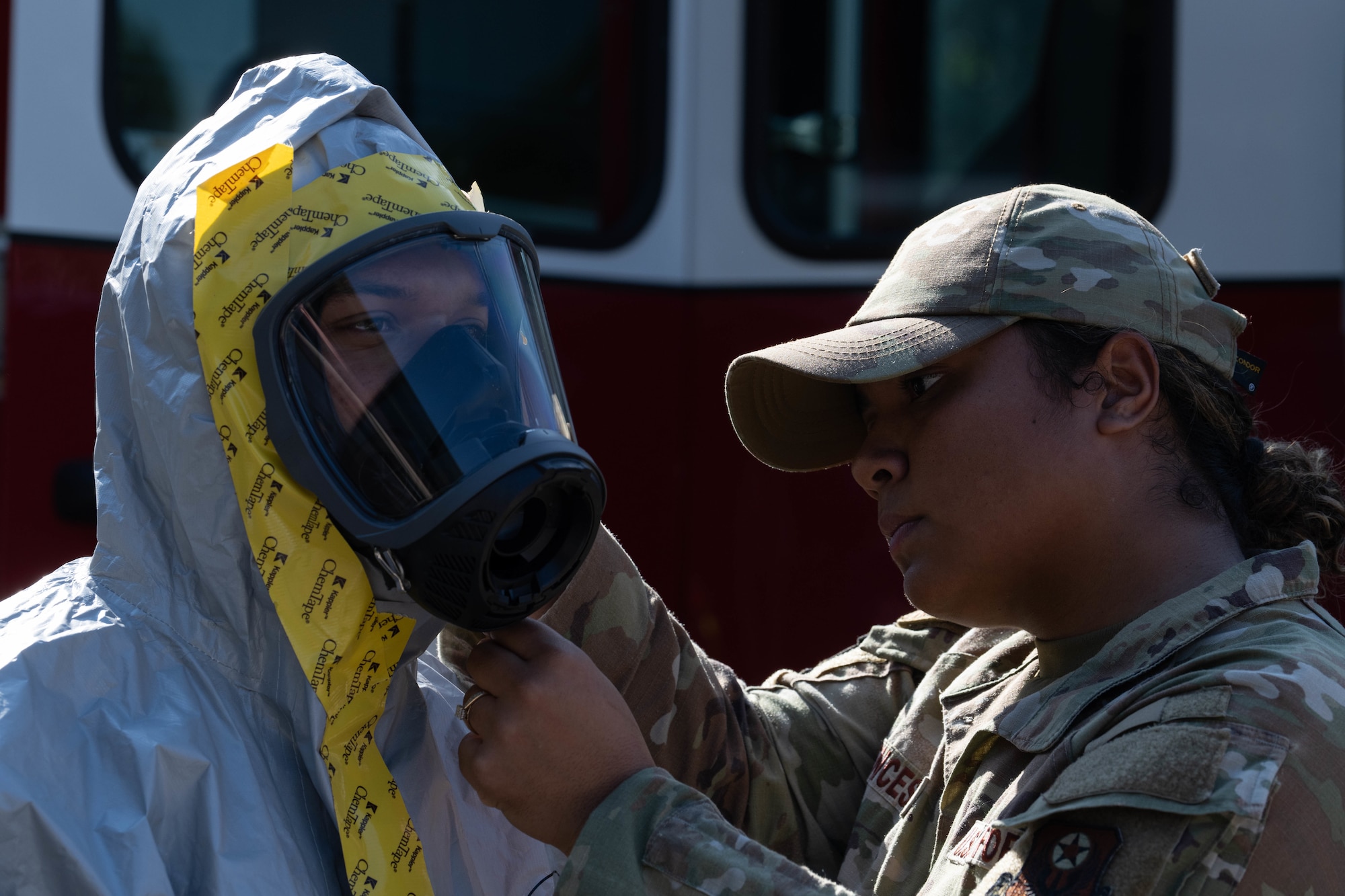 A U.S. Airmen assigned to the 1st Special Operations Wing dons a Chemical, Biological, Radiological and Nuclear suit with the help of another 1 SOW Airman during Exercise Commando Response, at Hurlburt Field, Florida, Sept. 8, 2025.