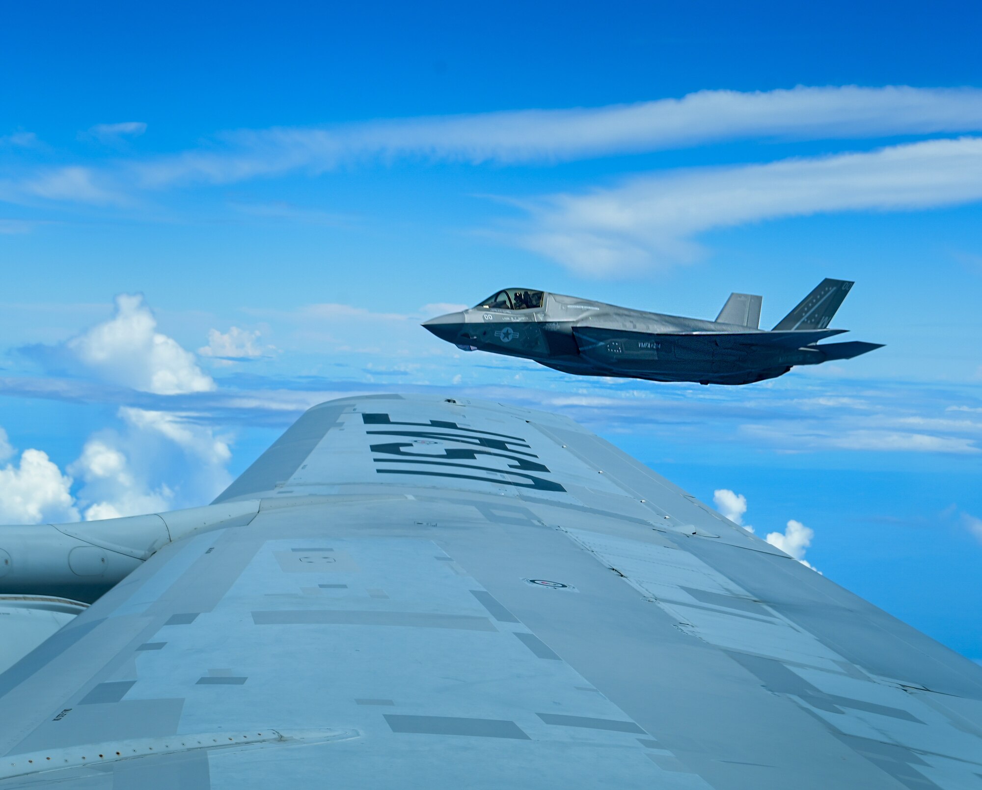 A U.S. Air Force and U.S. Marine Corps aircraft fly in formation.