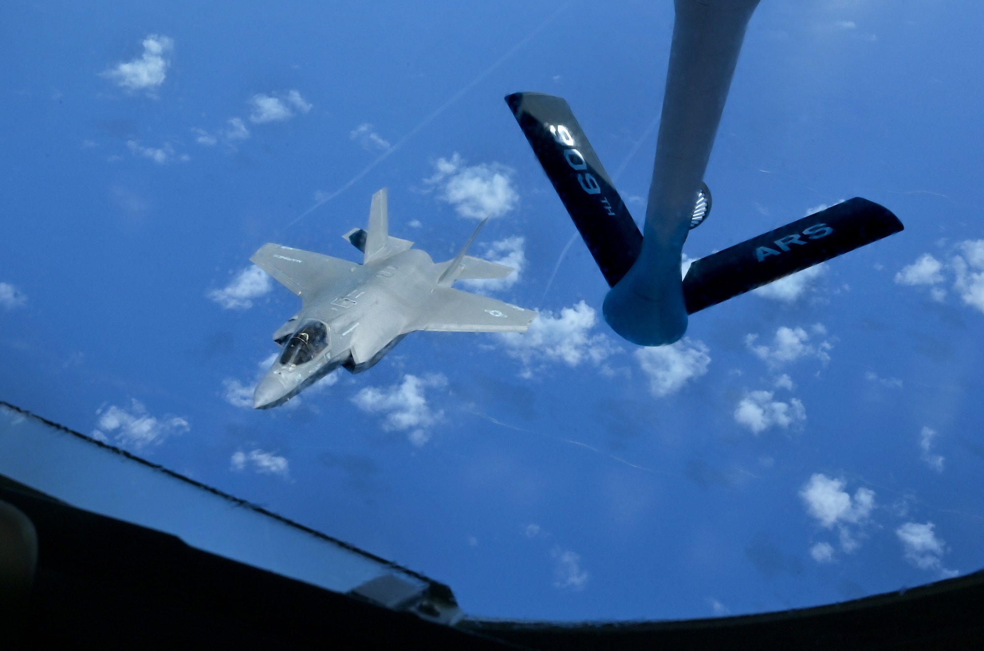 A U.S. Air Force and U.S. Marine Corps aircraft fly in formation.
