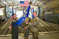 Col. Michael Medrano, 433rd Operations Group interim commander, presents the 433rd Contingency Response Squadron guidon to Major Alexander Williams, 433rd CRS commander, during a redesignation ceremony at Joint Base San Antonio-Lackland, Texas, Sept. 6, 2025.