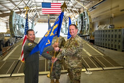 Col. Michael Medrano, 433rd Operations Group interim commander, presents the 433rd Contingency Response Squadron guidon to Major Alexander Williams, 433rd CRS commander, during a redesignation ceremony at Joint Base San Antonio-Lackland, Texas, Sept. 6, 2025.