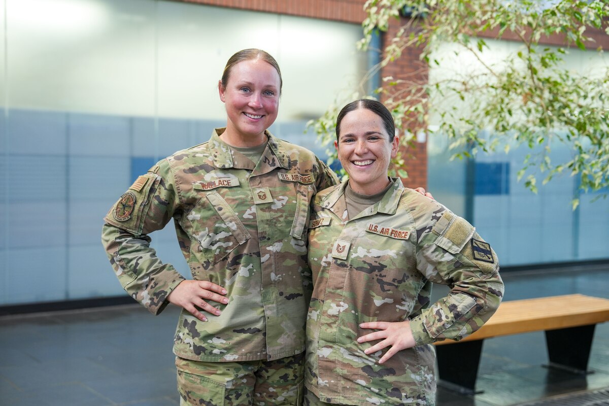 Two women in military uniform pose for a photo