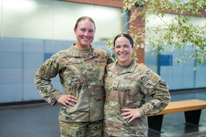 Two women in military uniform pose for a photo