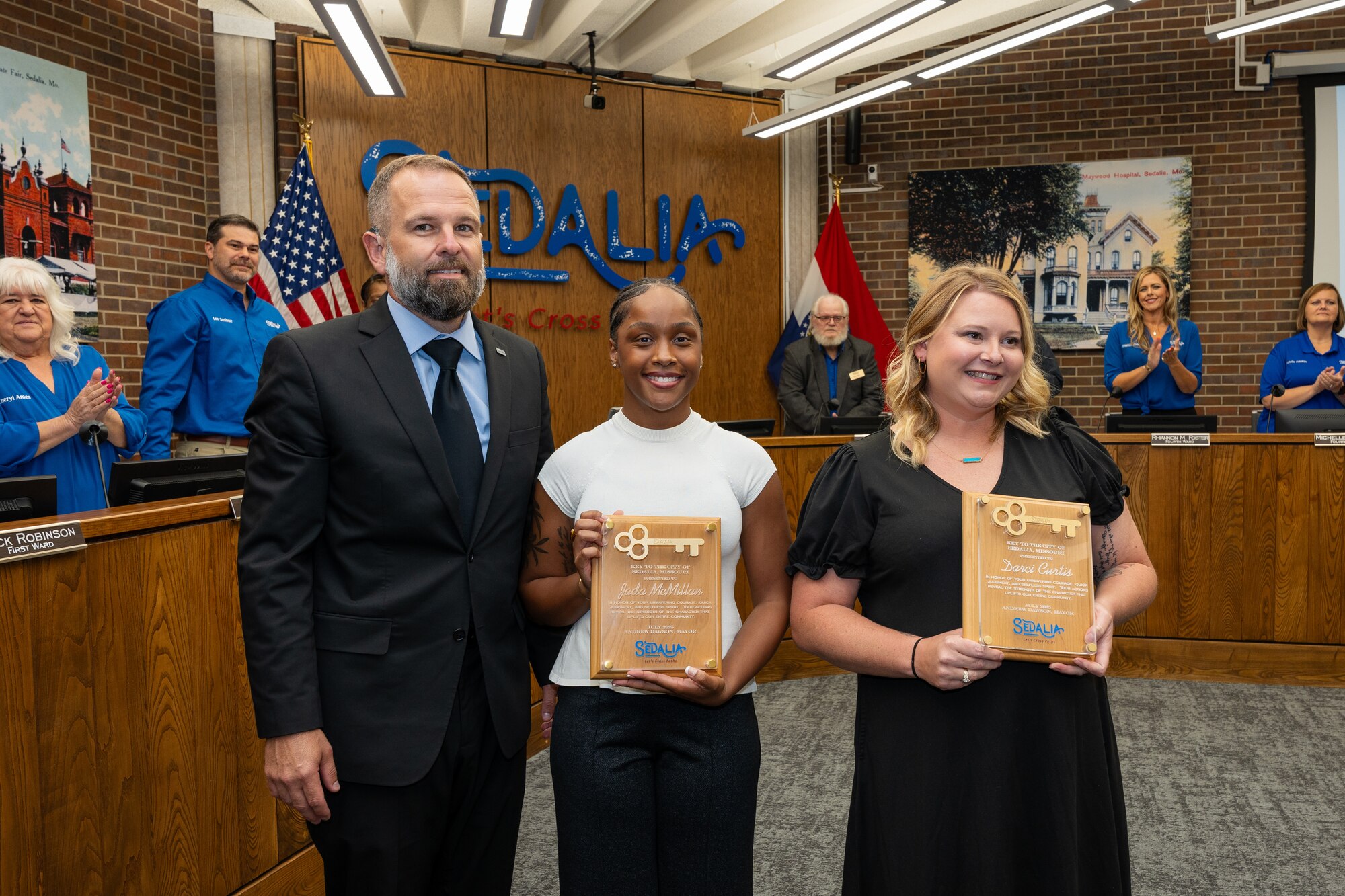 Andrew Dawson, the Mayor of the City of Sedalia, left, presents U.S. Air Force Senior Airman Jada McMillan, left, and Darci Curtis, 509th Medical Group healthcare professionals, with the key to the city in Sedalia, Missouri, Sept. 2, 2025.