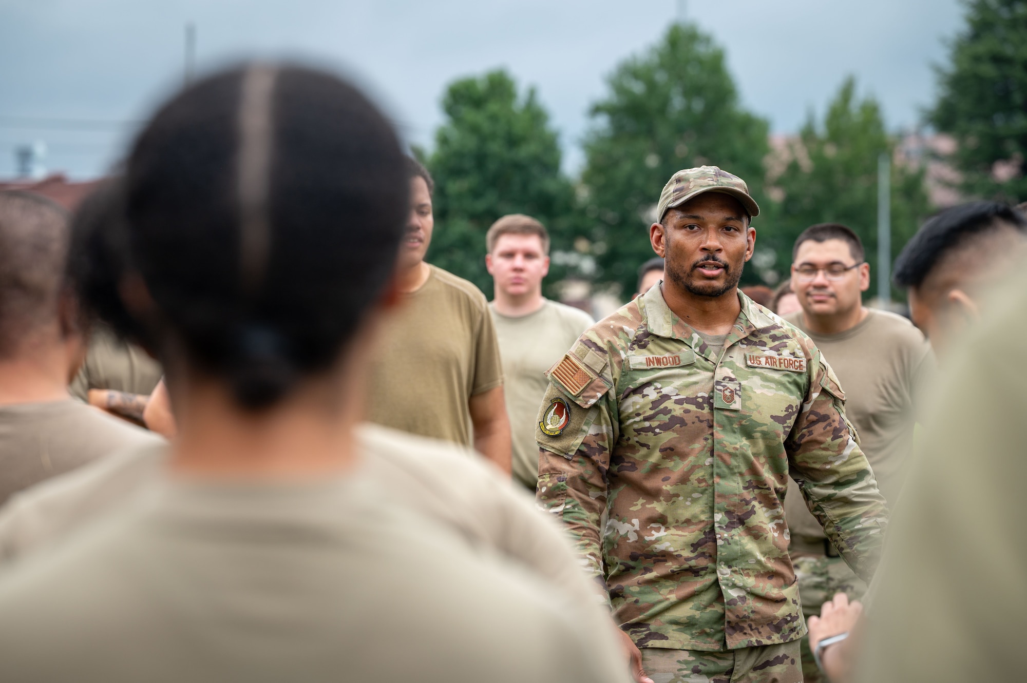 A servicemember speaks to other servicemembers crowding around him