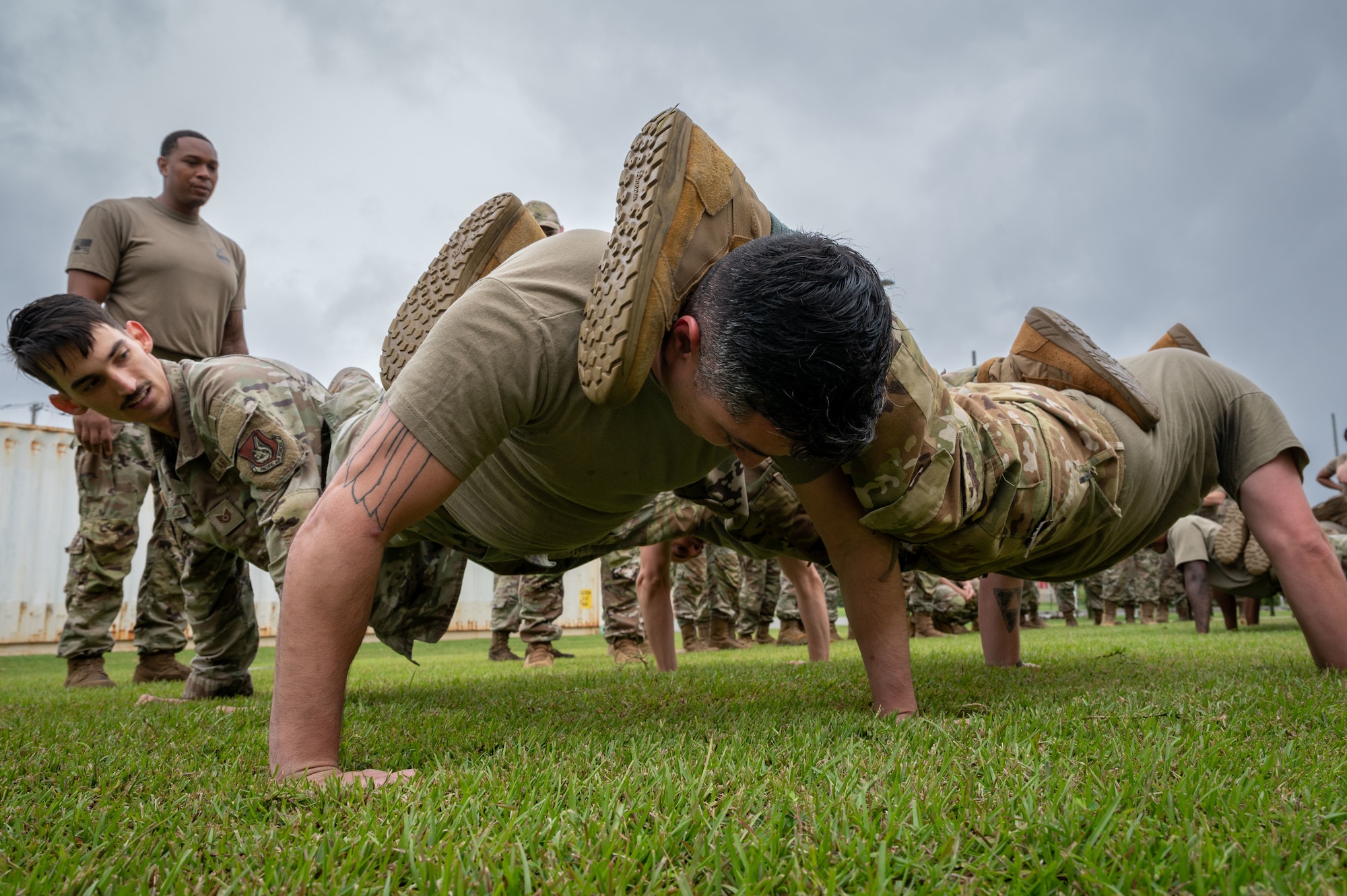 Servicemembers perform a four-man pushups