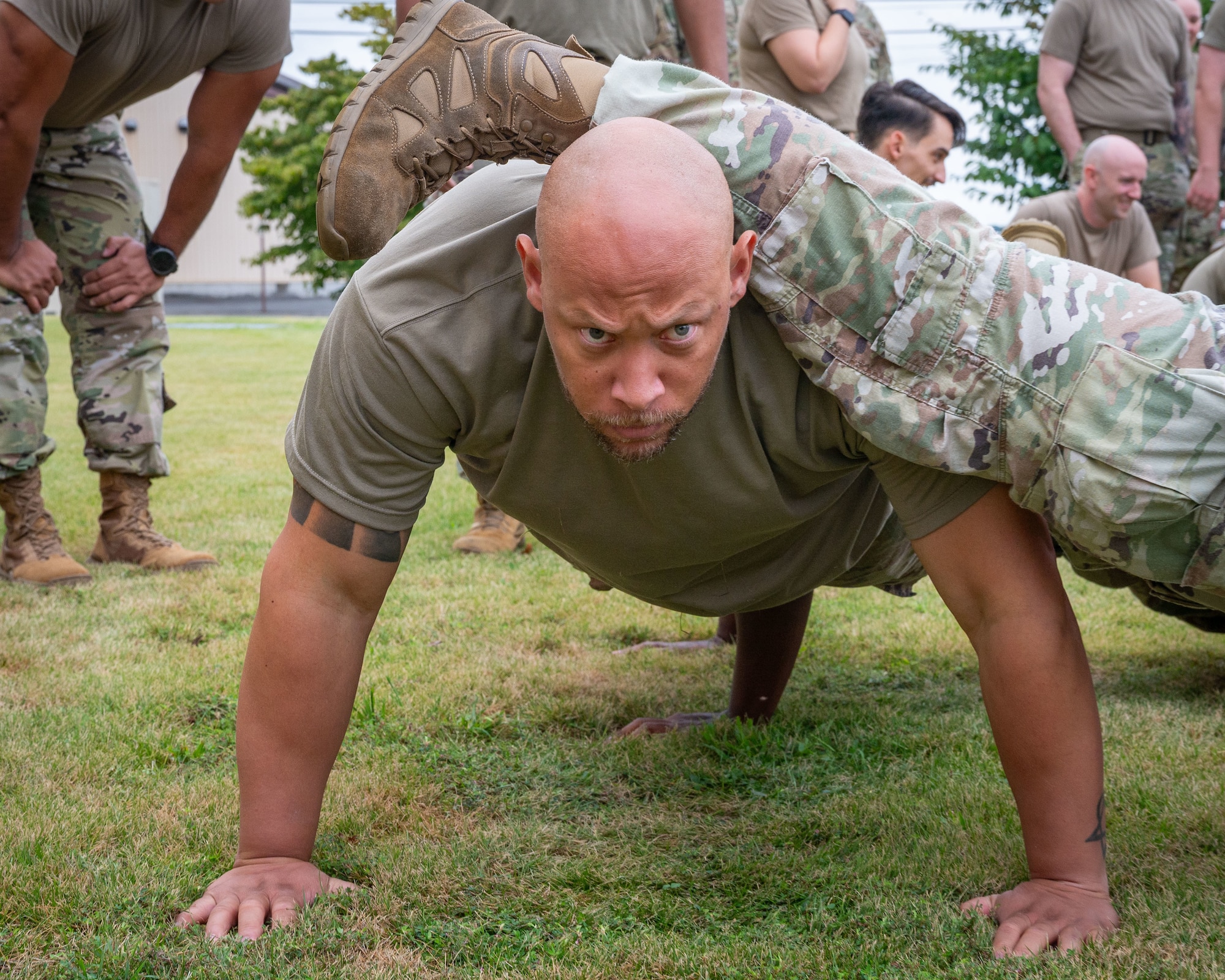 A servicemember performs a four-man pushup