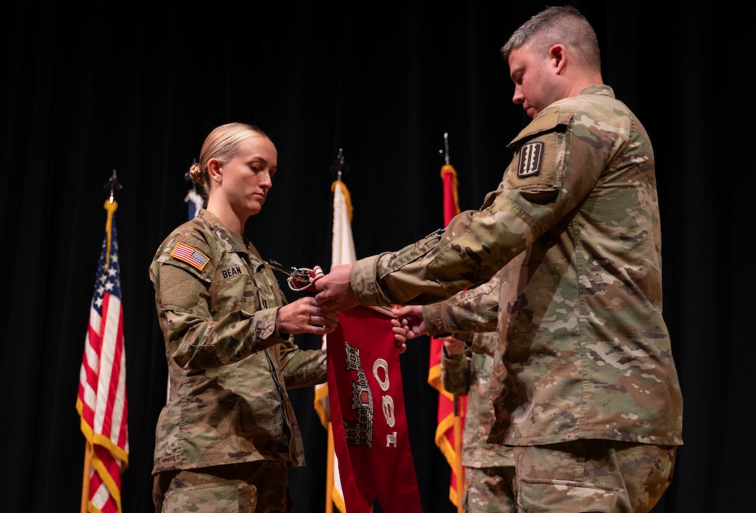 Company command team furls unit guidon during departure ceremony