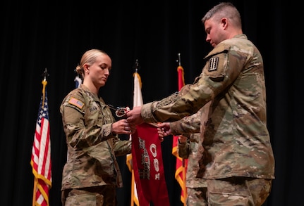Company command team furls unit guidon during departure ceremony