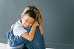 Young boy smiles and hugs mother