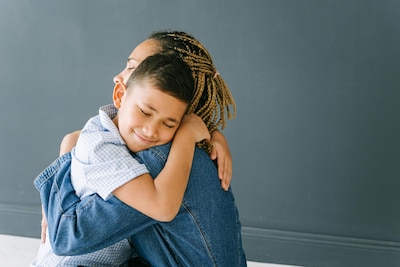 Young boy smiles and hugs mother