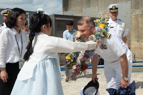 Capt. Louis Catalina, commanding officer of U.S. 7th Fleet flagship USS Blue Ridge (LCC 19) receives flowers as a welcome gift during a routine port visit to Pyeongtaek, South Korea, Sept. 18, 2025.