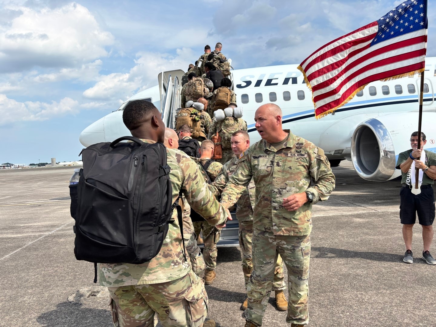 Georgia Army National Guard State Command Sergeant Major John Ballenger and Colonel Christopher Powell, commander of the 648th Maneuver Enhancement Brigade, shake hands with Soldiers of the 863rd Engineer Utilities Detachment as they board a plane for training at Hunter Army Airfield, Ga., before the unit's mobilization in support of United States Africa Command.