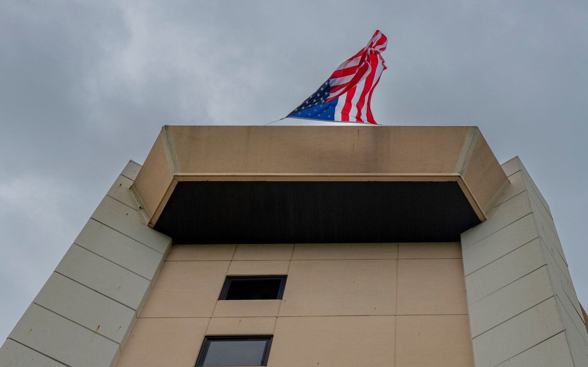 A U.S. flag is draped over the 6th Air Refueling Wing Air Traffic Control Tower during a 9/11 Memorial climb at MacDill Air Force Base, Florida, Sept. 11, 2025. Participants climbed nine flights of stairs 411 times to honor the sacrifice first responders made during the Sept. 11, 2001, terrorist attacks on the World Trade Center. (U.S. Air Force photo by Airman 1st Class Monique Stober)