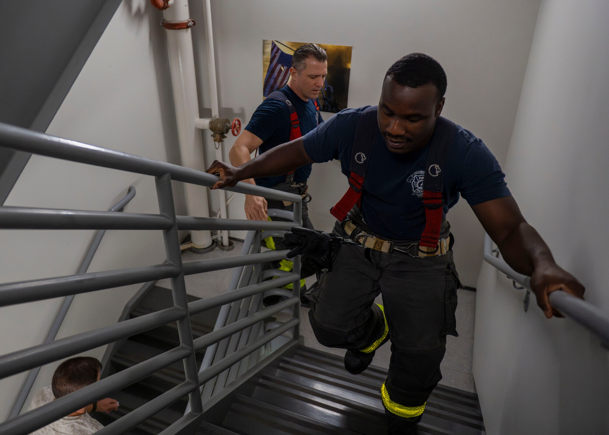 Hillsborough County firefighters ascend the Air Traffic Control Tower stairs during a 9/11 Memorial Climb at MacDill Air Force Base, Florida, Sept. 11, 2025. Firefighters and Airmen carried the names of fallen first responders up nine flights of stairs 411 times, once for each name, placing each on a dedicated board on the 9th floor as a tribute to their bravery and sacrifice. (U.S. Air Force photo by Airman 1st Class Monique Stober)