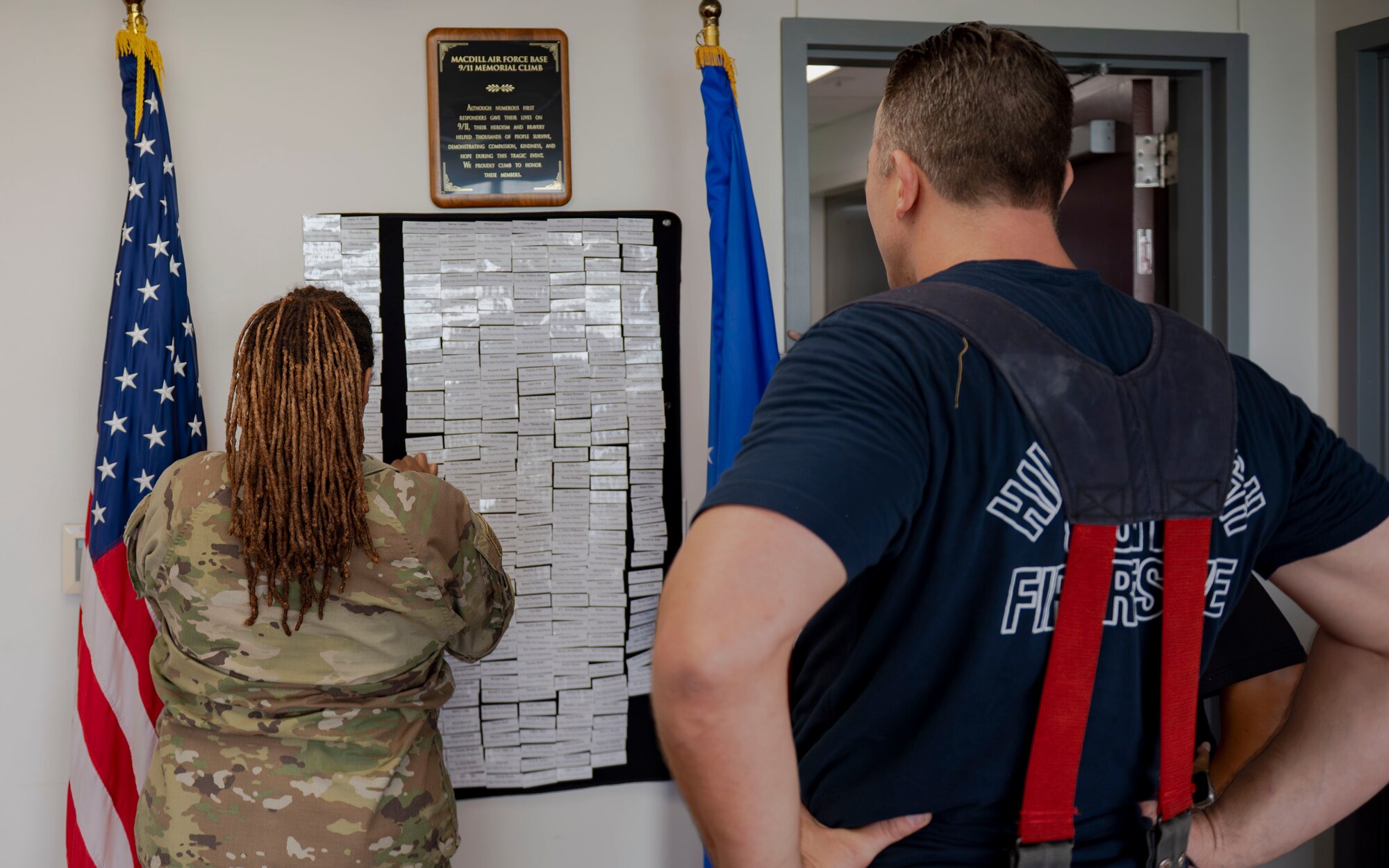 Service members and Hillsborough County firefighters place the names of first responders whose lives were lost during the Sept. 11, 2001, terrorist attacks on a dedicated board during a 9/11 Memorial Climb at MacDill Air Force Base, Florida, Sept. 11, 2025. Participants climbed nine flights of stairs 411 times to honor the 411 first responders who lost their lives during the terrorist attacks on the World Trade Center. (U.S. Air Force photo by Airman 1st Class Monique Stober)