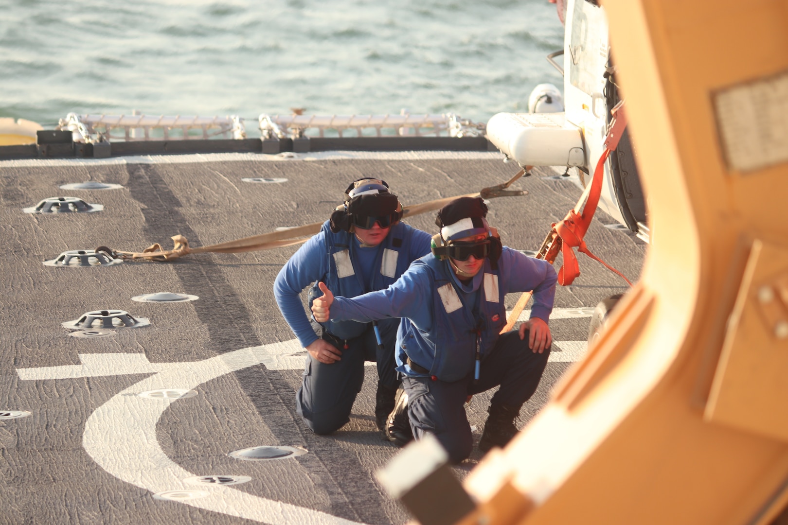 Coast Guard Cutter Spencer (WMEC 905) tie-down crew members secure an MH-60 Jayhawk helicopter from Air Station Elizabeth City during flight operations in the Chesapeake Bay, June 26, 2025. Routine flight operations maintain crew proficiency and readiness. (U.S. Coast Guard photo by Petty Officer 2nd Class Andrew Blosser)