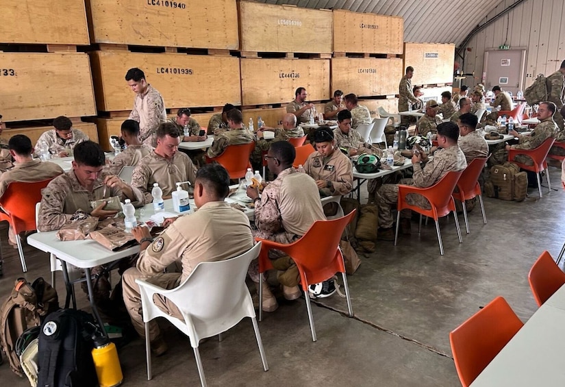 Several people sit at tables, eating.