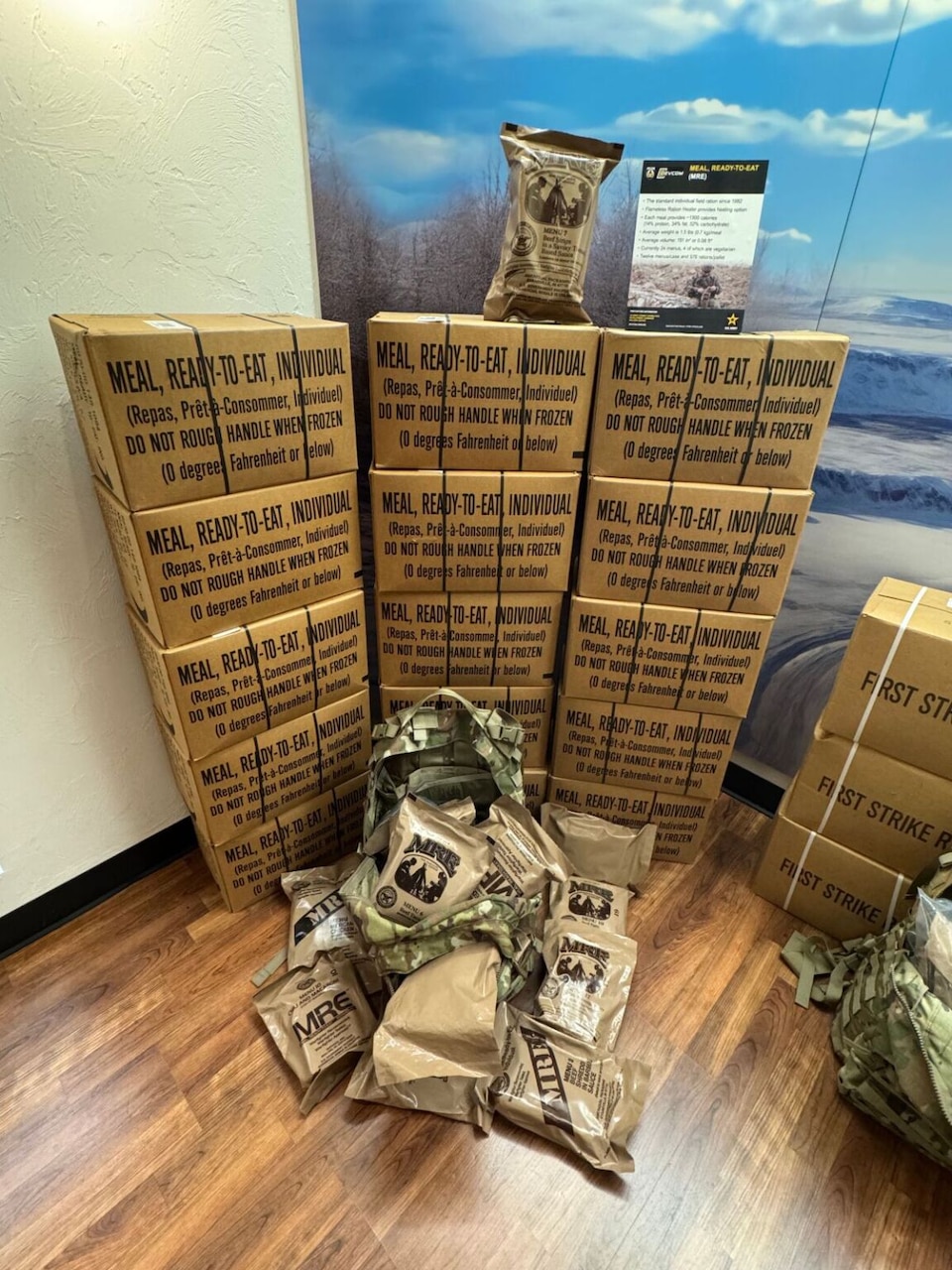 A rucksack overflowing with plastic-packaged meals sits in front of a display of boxes.