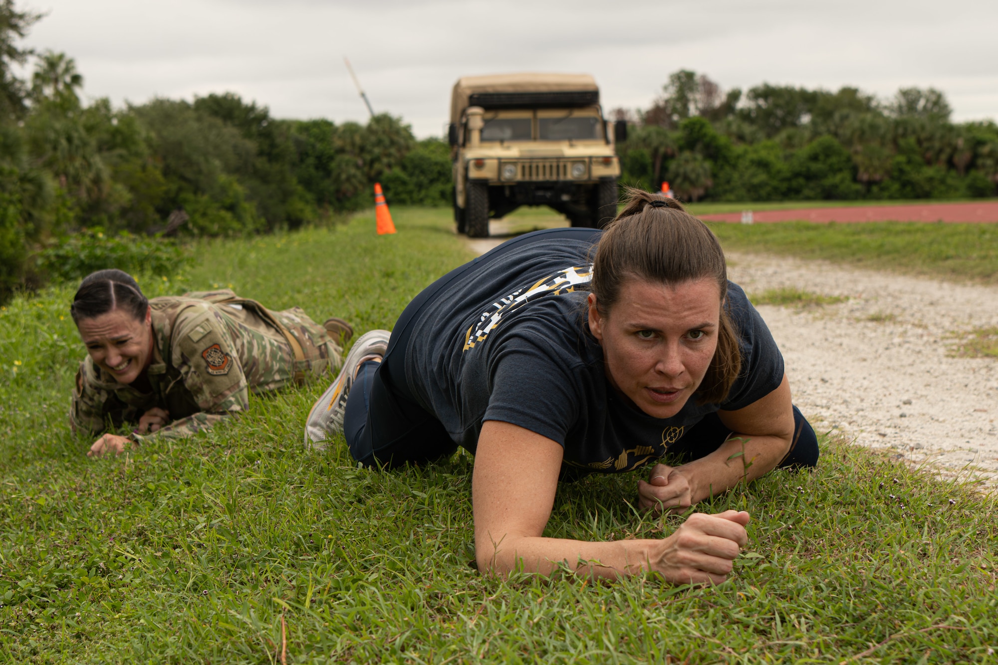 U.S. Air Force Master Sgt. Erica Hudson, 6th Security Forces Plans and Programs superintendent, and Senior Master Sgt. Kara Marszalek, 6th SFS first sergeant, low crawl during the 16th Annual Helton Week defender’s challenge at MacDill Air Force Base, Florida, Sept. 10, 2025. The challenge was held in memory of 1st Lt. Joseph D. Helton Jr. who was the first security forces officer killed in military operations since the Vietnam War, Sept. 8, 2009. (U.S. Air Force photo by Airman 1st Class Helen Ly)