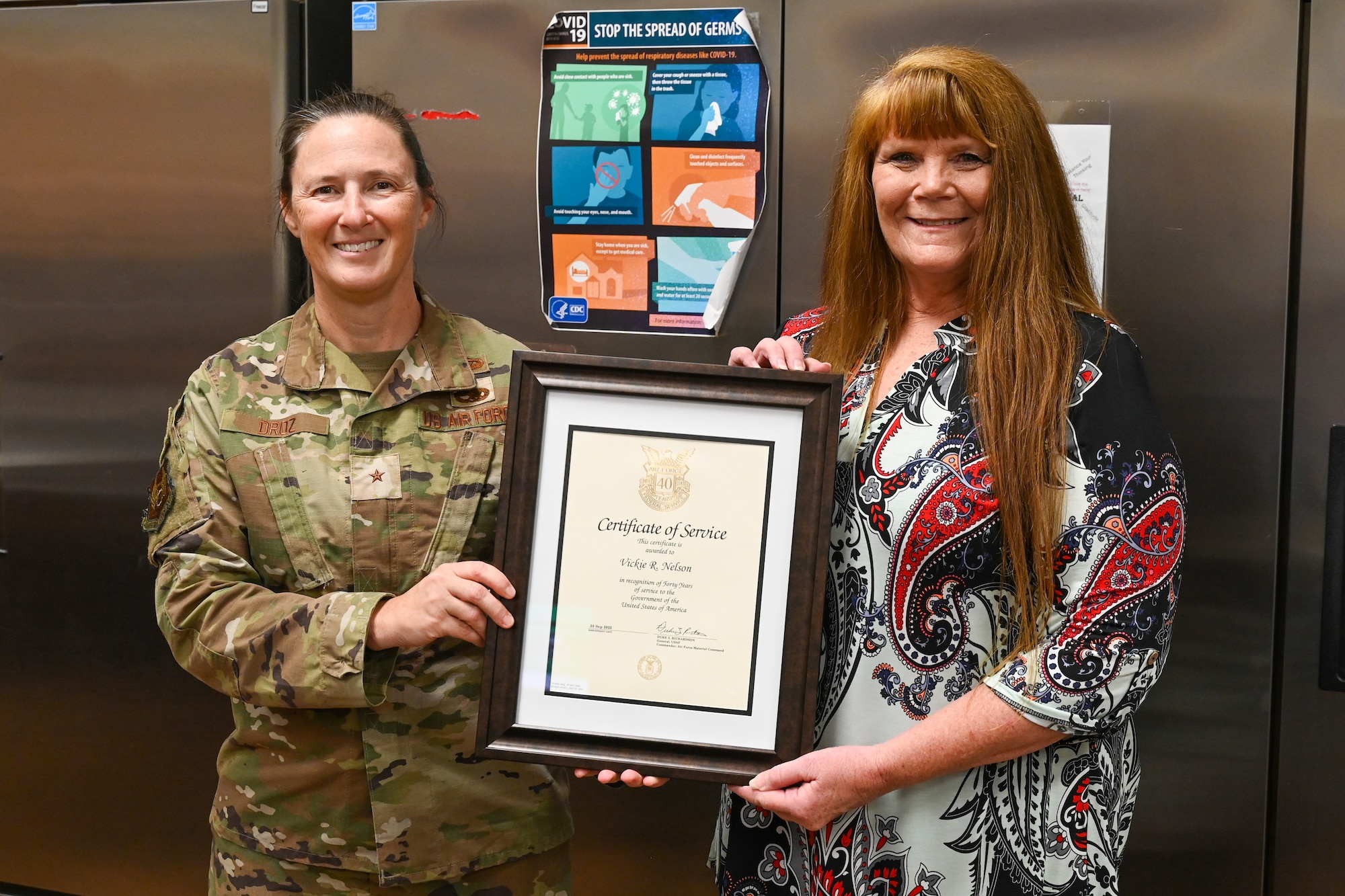 Two women hold a certificate