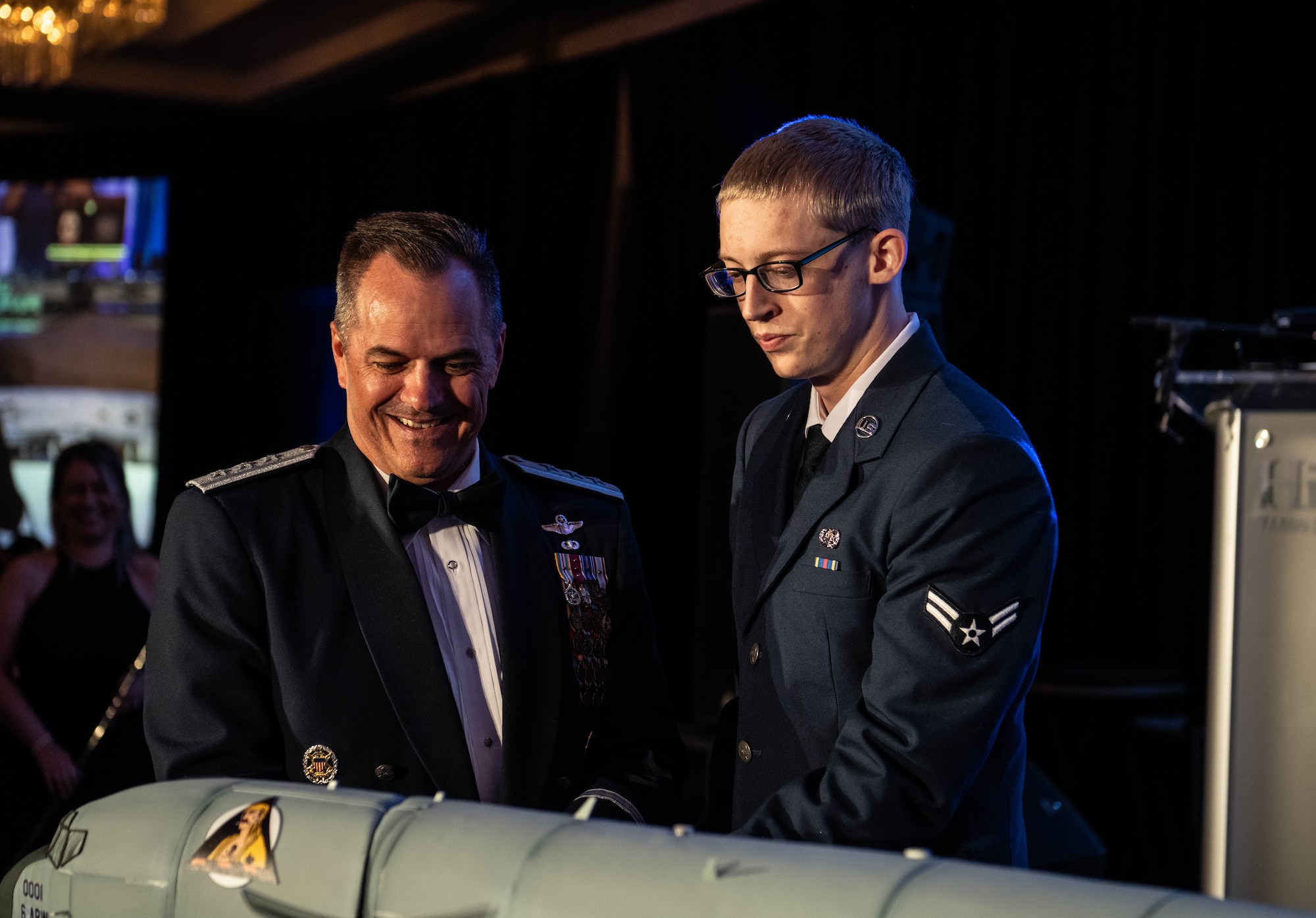 U.S. Air Force Lt. Gen. Sean Farrell, U.S. Special Operations Command deputy commander, left, and Airman 1st Class Noah Fritz, 6th Communications Squadron cybersecurity technician, cut the cake during the Air Force Ball in Tampa, Florida, Sept. 13, 2025. The cake cutting is an Air Force Ball tradition held by the most senior and junior person in attendance. (U.S. Air Force photo by Staff Sgt. Christopher Tam)