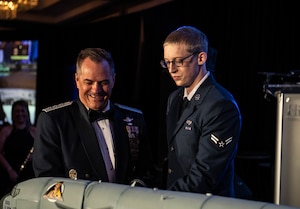 U.S. Air Force Lt. Gen. Sean Farrell, U.S. Special Operations Command deputy commander, left, and Airman 1st Class Noah Fritz, 6th Communications Squadron cybersecurity technician, cut the cake during the Air Force Ball in Tampa, Florida, Sept. 13, 2025. The cake cutting is an Air Force Ball tradition held by the most senior and junior person in attendance. (U.S. Air Force photo by Staff Sgt. Christopher Tam)
