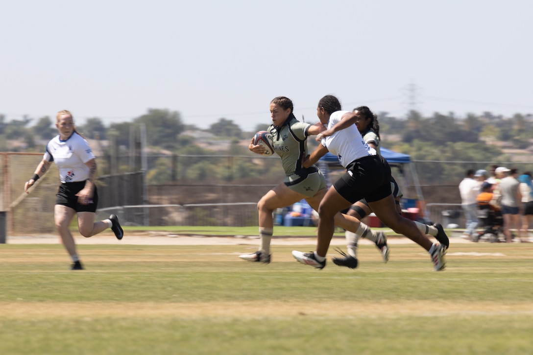 U.S. Marine Corps Sgt. Kendall Curtis, an aircraft ordnance technician with Marine Light Attack Helicopter Training Squadron (HMLAT) 303, Marine Aircraft Group 39, 3rd Marine Aircraft Wing, advances the ball during the 2025 Armed Forces Championship in Chula Vista, San Diego, Sept. 6, 2025. The Marine Corps Sports Program enables exceptional Marine athletes to compete in the AFC to promote goodwill through competitive sports across the service branches. (U.S. Marine Corps Photo by Lance Cpl. Nan Yang)