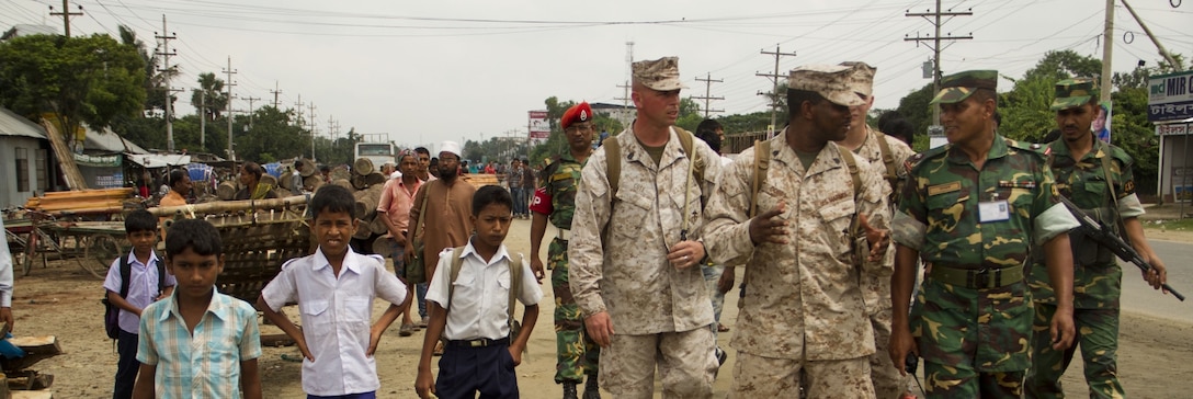 Civil Military Operations Marines Gunnery Sgt. Shane Cote, Sgt. Edward Cobbs, and Lance Cpl. Christopher Schlesinger are joined by local schoolchildren while on a civil engagement near Hazi Joynuddin High School in Dhaka, Bangladesh, Sept. 3, 2012. The CMO Marines were attached to Marine Wing Support Squadron 171 (MWSS-171) went to Bangladesh as a part of an Engineering Civil Action Program to enhance the relationship between the United States and Bangladesh by building the second story of Hazi Joynuddin High School.