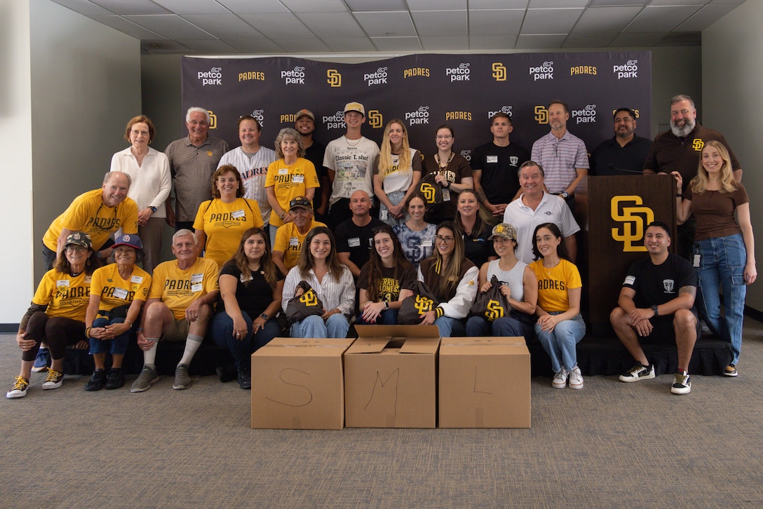 U.S. Marines, members of the San Diego Padres organization, and volunteers pose for a photo after assembling care packages to be shipped to Marines with Marine Fighter Attack Squadron (VMFA) 232, MAG-11, 3rd MAW at Petco Park, San Diego, CA, Sept. 15, 2025. VMFA-232 is currently attached to MAG-12, 1st MAW, as part of the unit deployment program, enhancing squadron readiness and providing flexible fighter attack capabilities to support U.S. forces in the Indo-Pacific region. The San Diego Padres demonstrate their commitment to U.S. service members and their families with over 30 years of support through donations, Military Sundays, and community programs via the Padres Foundation. (U.S. Marine Corps photo by Lance Cpl. Samantha Devine)