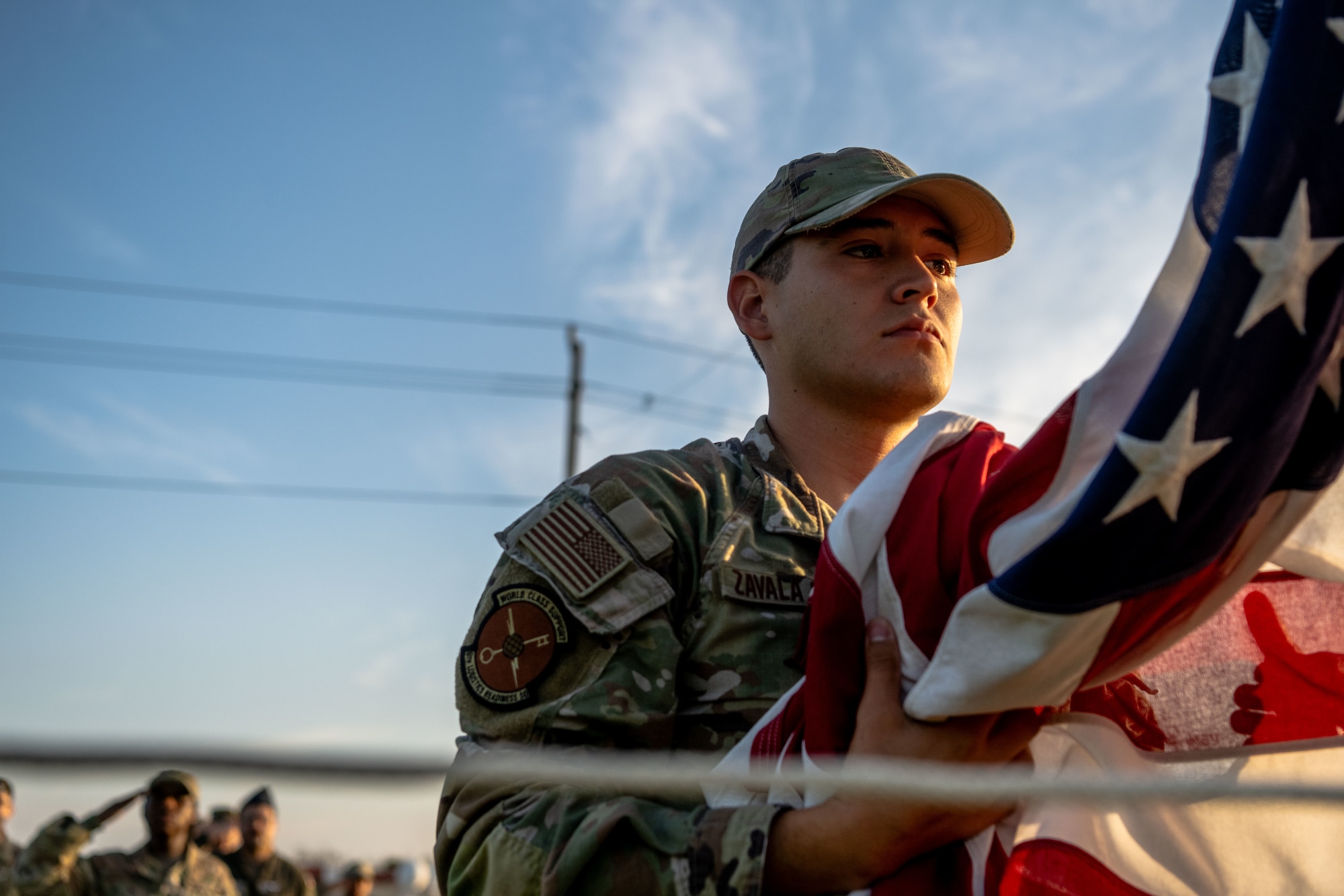 U.S. Air Force Senior Airman Sergio Zavala Salas, Airman Leadership School Class 25-F student, lowers the flag  at MacDill Air Force Base, Florida, Sept. 2, 2025. ALS students performed reveille and retreat practices daily. The repetition allowed students to embody the Air Force’s core values while executing a long standing military tradition. (U.S. Air Force photo by Senior Airman Zachary Foster)