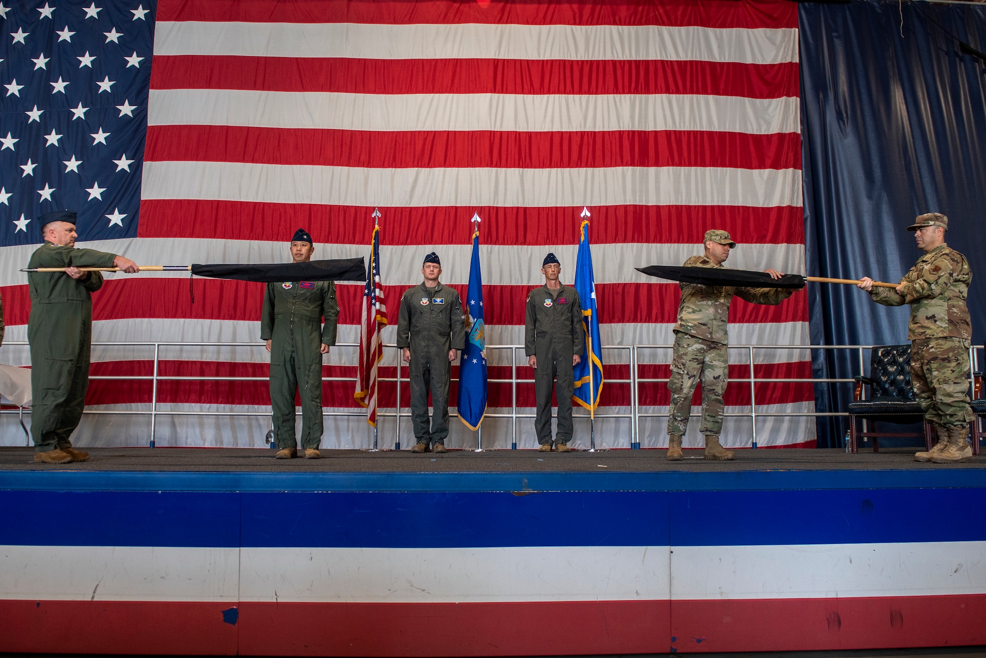 Leaders from the 25th Attack Group & 432d Maintenance Group furl their guidon flag during a wing redesignation ceremony at Shaw Air Force Base, South Carolina, Sept. 18, 2025.