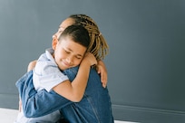 Young boy smiles and hugs mother