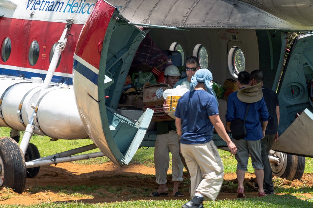 U.S. service members assigned to Defense POW/MIA Accounting Agency offloads gear from a MIL MI-17 helicopter in preparation for recovery operations in Ha Tinh Providence, Vietnam, May 29, 2025.