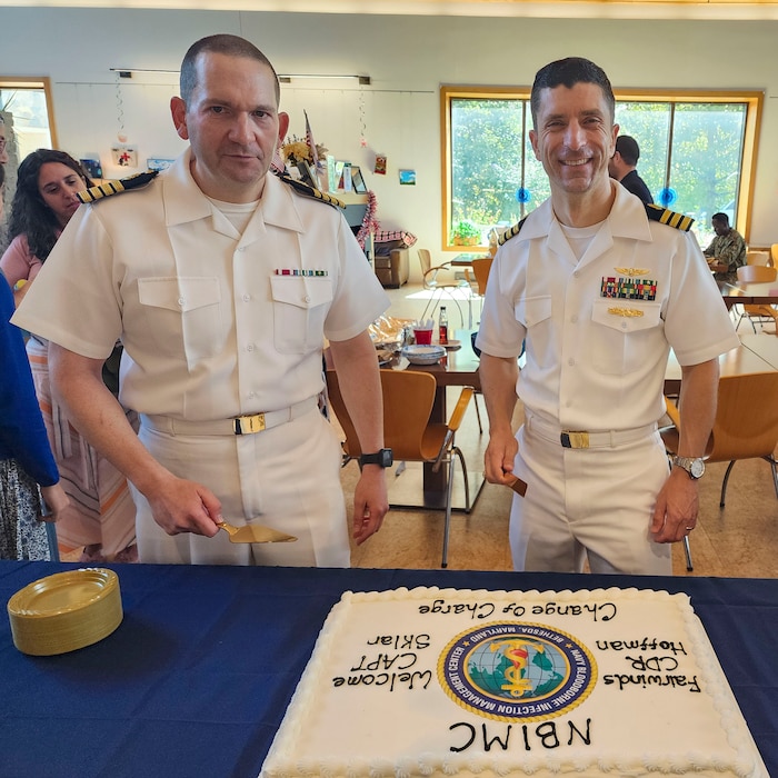 250910-O-NJ594-1178, Bethesda, Maryland, (August 22, 2025) -- Cmdr. Marshal Hoffman, outgoing officer in charge, right, and Captain Sklar, oncoming officer in charge, Navy Bloodborne Infection Management Center, left, poses for a photo during a change of charge ceremony at United Service Organization (USO) in Bethesda, Maryland, Aug. 22, 2025. The event honored Hoffman’s accomplishments and welcomed Sklar as the new officer in charge, reaffirming the center’s role in medical readiness, force health protection, and compassionate care for service members. (U.S. Navy photo by Ai Marrero)