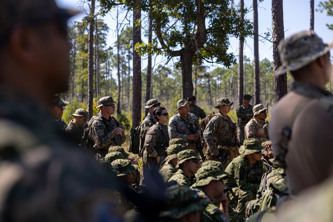 U.S. Marines with 2nd Battalion, 2nd Marine Regiment, and marines and naval infantry with, Corpo de Fuzileiros Navais (Brazilian marine corps), Cuerpo de Infantería de Marina (Chilean Maine Corps), Infantería de Marina Colombiana (Colombian marine corps) and Infantería de Marina de la Armada de la República Argentina, (Naval Infantry of the Argentine Navy), get a class on patrol lanes during exercise UNITAS 2025 at Marine Corps Base Camp Lejeune, North Carolina, Sept. 17, 2025. UNITAS, which is Latin for “unity,” was conceived in 1959 and has taken place annually since first conducted in 1960. This year marks the 66th iteration of the world’s longest running annual multinational maritime exercise. (U.S. Marine Corps photo by Lance Cpl. Payton Goodrich)