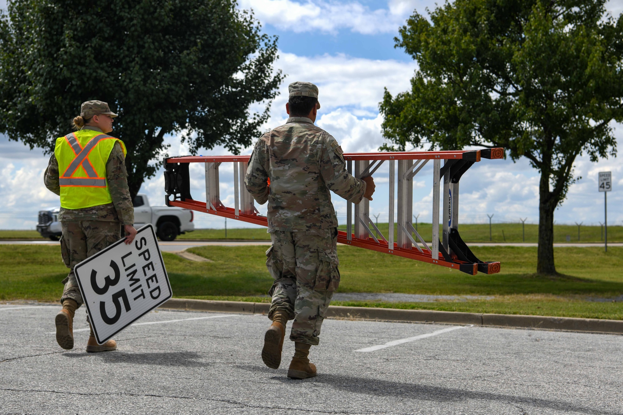 Service members replace a speed limit sign.