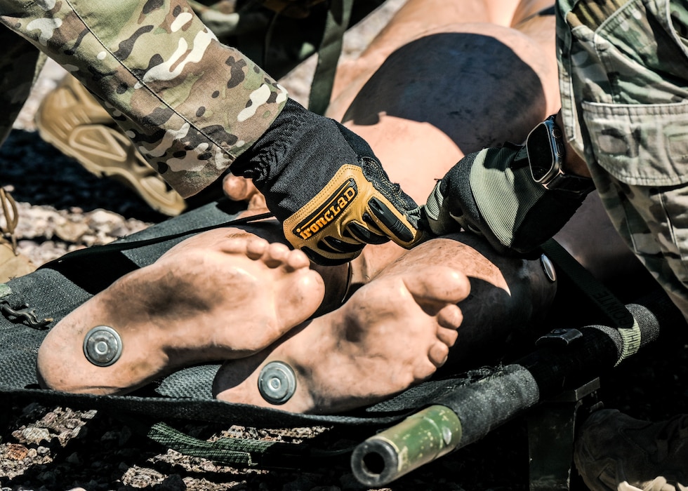 U.S. Air Force Senior Airmen Mac Little (left) and Andrayez Storm (right), 56th Civil Engineer Squadron explosive ordnance disposal technicians, secure a rescue manikin in a portable stretcher