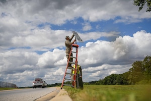 Service members replace a speed limit sign.