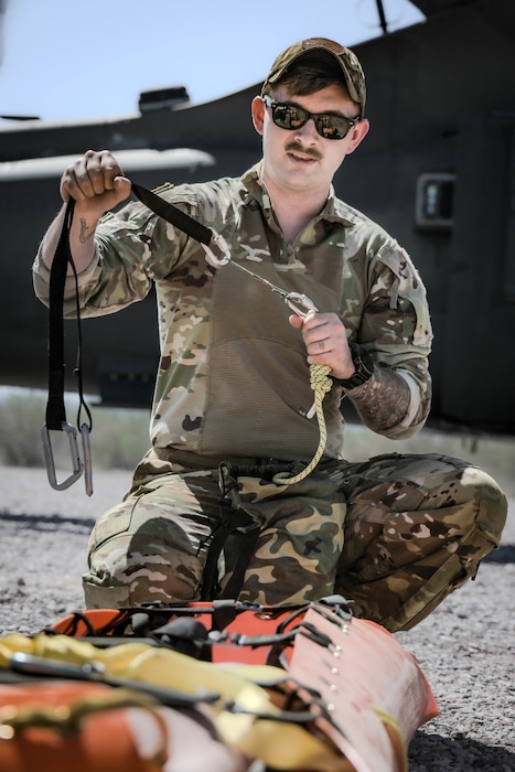 U.S. Army Staff Sgt. Cody Solomon, a flight paramedic assigned to Charlie Company, 2nd General Support Aviation Battalion, 1st Aviation Regiment, 1st Combat Aviation Brigade, 1st Infantry Division, teaches Airmen how to safely secure and prepare a casualty for transport