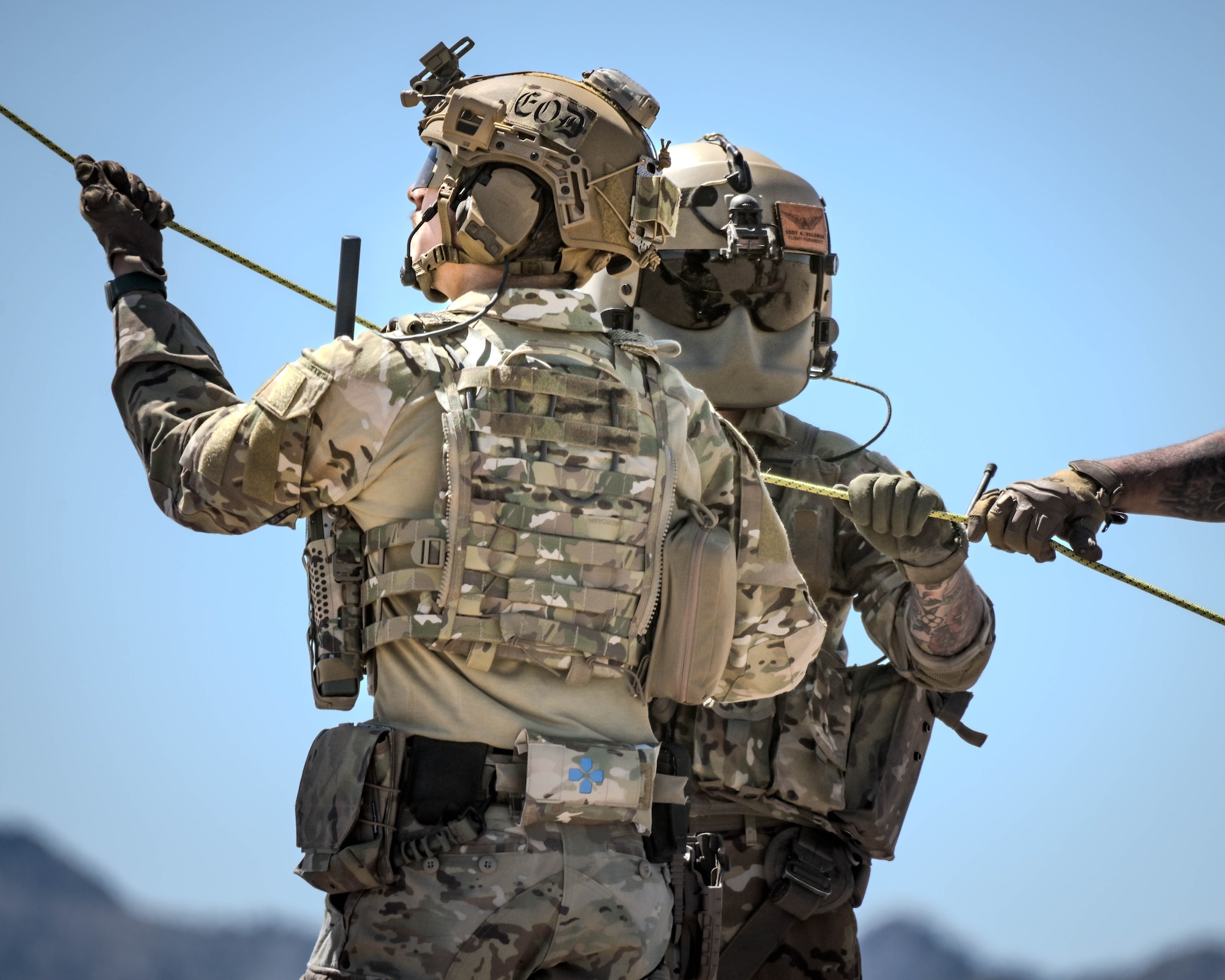 U.S. Air Force Senior Airman Elias Saavedra (left), 56th Civil Engineer Squadron explosive ordnance disposal technician, and U.S. Army Soldier Staff Sgt. Cody Solomon (right), a flight paramedic assigned to Charlie Company, 2nd General Support Aviation Battalion, 1st Aviation Regiment, 1st Combat Aviation Brigade, 1st Infantry Division, conducts a hoist extraction of a casualty via stretcher into a hovering helicopter